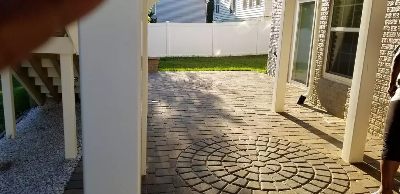 Patio with dual circular paver medallions under porch