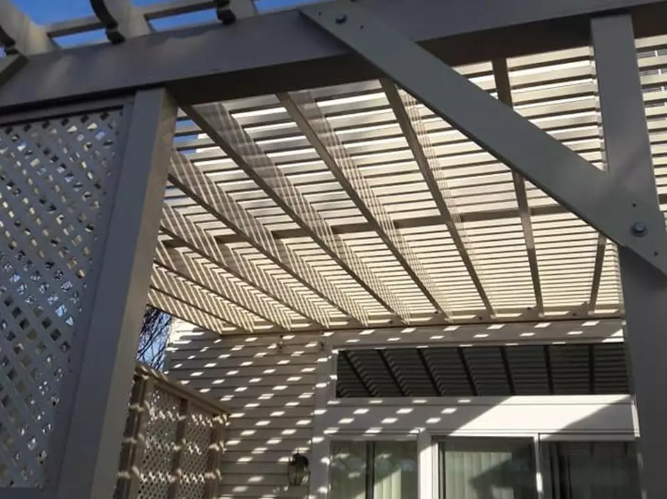 White pergola casting striped shadows