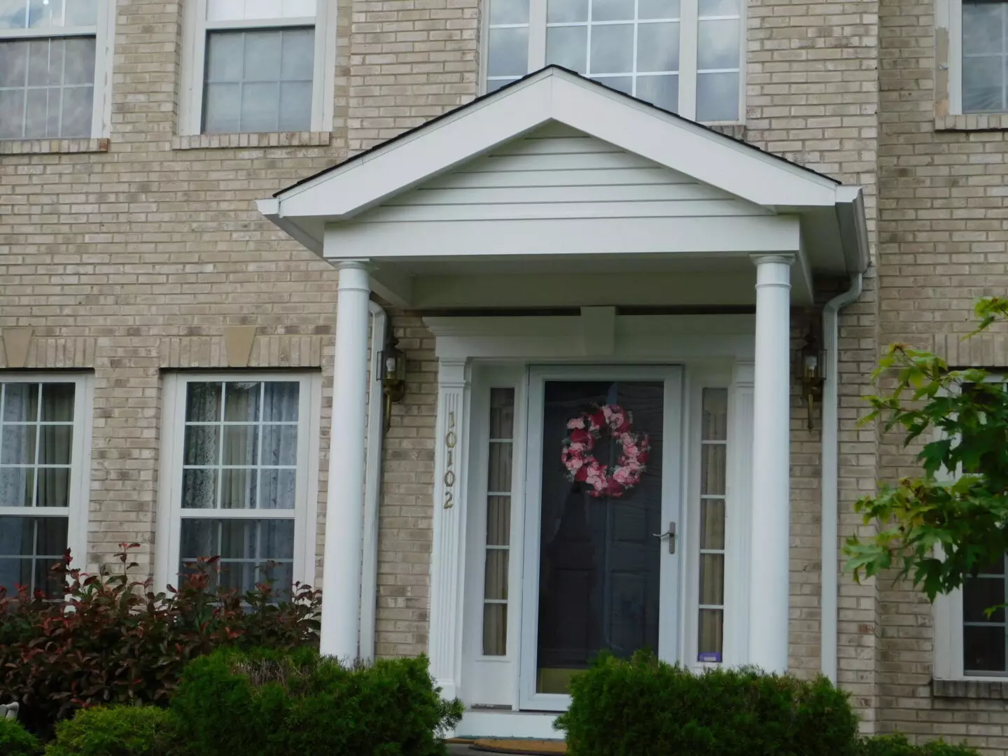 Entrance of a light brick house with a decorated door