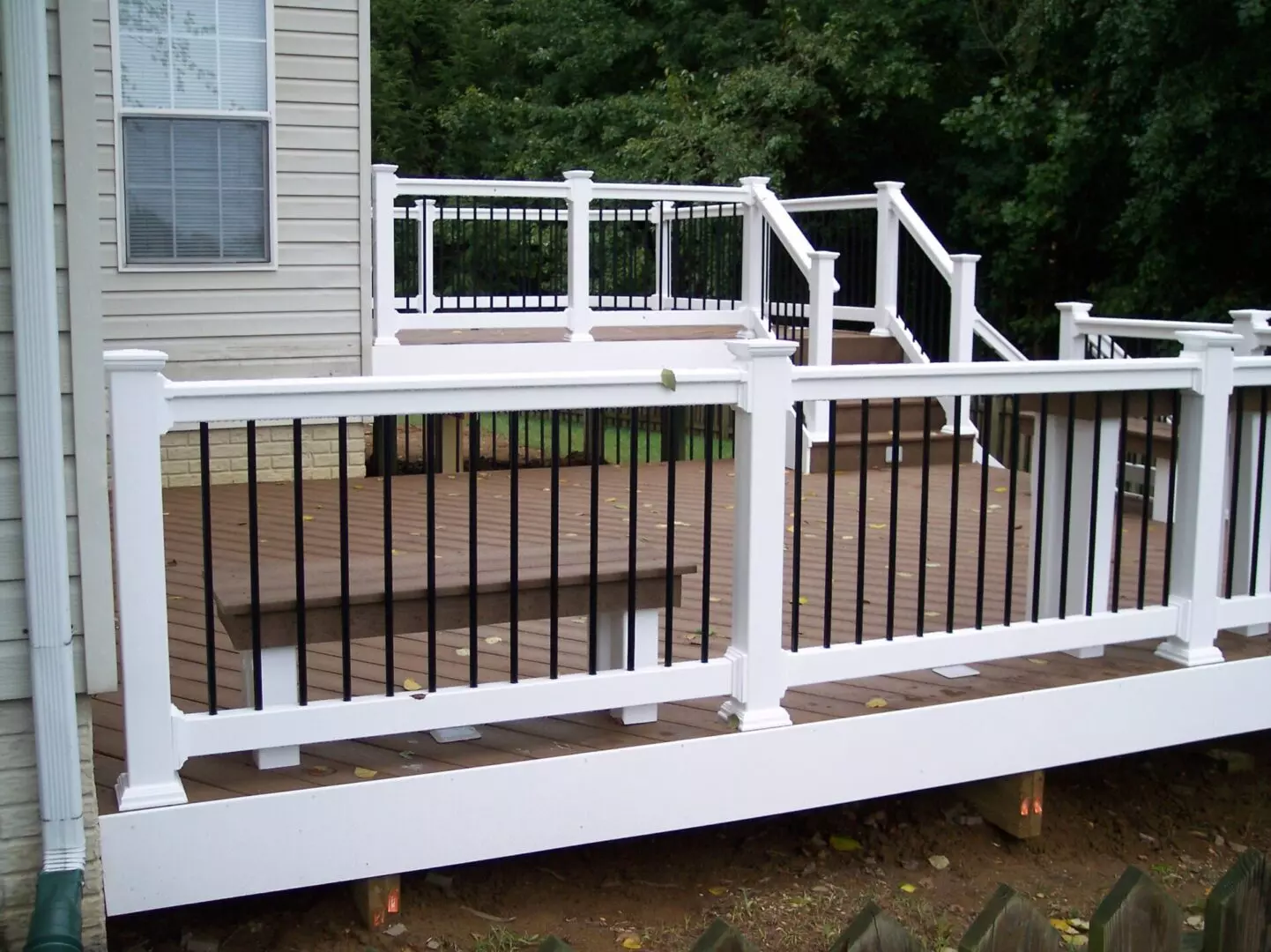 An empty white deck with a brown wooden floor
