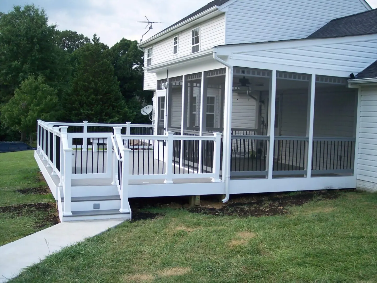 White wooden deck and screened porch attached to a house.
