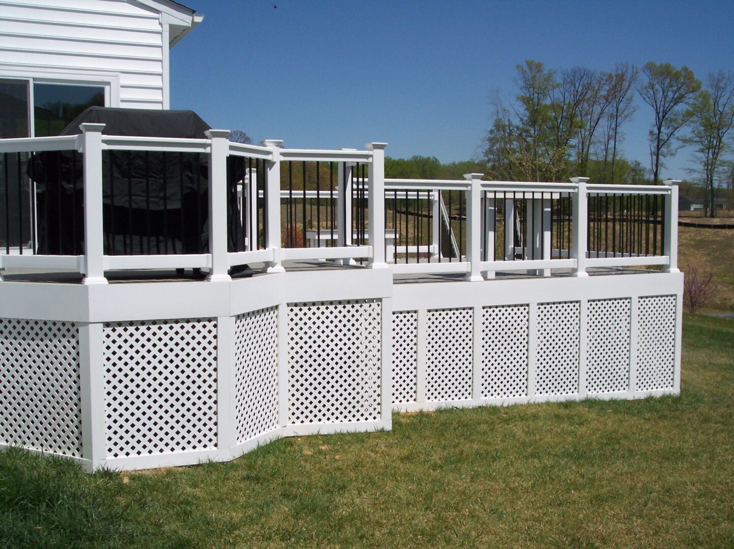 Spacious and elevated white wooden deck with black metal barriers